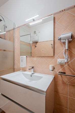 Chuveiro, secador de cabelo, bidê, toalhas de banho
