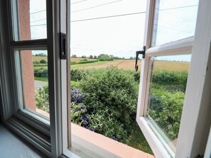 A window with a view of a rural landscape, including fields and greenery. - The Mallows (Walsingham)
