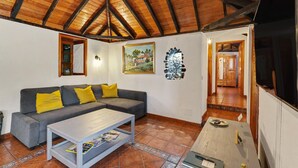 A living room with a sofa, coffee table, and artwork on the walls. - Apartment 'Tocando El Cielo' with Mountain View, Private Terrace and Wi-Fi (Barrial de Arriba)