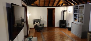 Un salon chaleureux avec une cheminée, un canapé et un meuble.