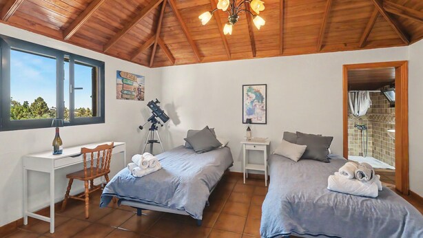A bedroom with two beds, a desk, a telescope, and a large window. - Apartment 'Tocando El Cielo' with Mountain View, Private Terrace and Wi-Fi (Barrial de Arriba)