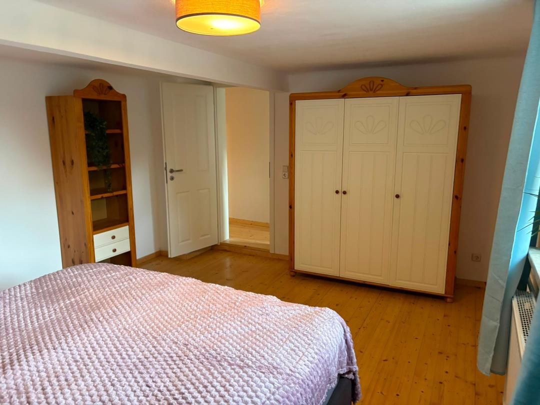Ein Schlafzimmer mit Bett, Kleiderschrank und Tür.