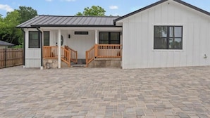A single-story building with a porch, a small staircase, and a fenced yard. - Freshly Renovated 2BR in E Austin High End Finishes Near Downtown Nightlife (Austin)