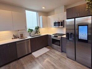 A modern kitchen with stainless steel appliances, a microwave, and a built-in oven. - Capitol Hill Rooftop Hot Tub Close to Light Rail (Seattle)