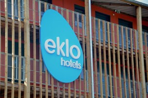 Un letrero de hotel con el nombre 'eklo hotels' sobre un fondo azul.