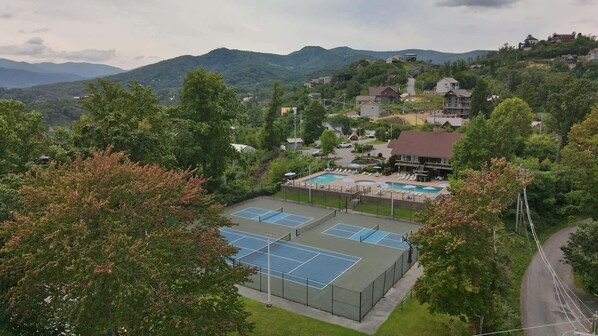 Ein Wohngebiet mit Tennisplatz, Schwimmbad und Häusern an einem Hang.