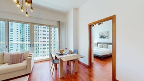 A modern apartment with a dining area, a sofa, and a bed. - Calm 1 Bedroom l Free Wi-Fi l Stunning Marina View (Dubai)