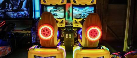 Twee spelautomaten voor racegames met schermen en verlichte zitplaatsen.