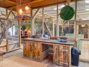 A rustic wooden kitchen with a large island, hanging lights, and a green spherical decoration. - Berney Lodge - Puppy Lounge Arcades Games Room (Market Rasen)