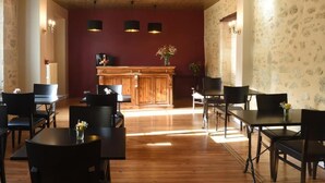 A dining area with wooden tables and chairs, a central bar area, and patterned wallpaper.