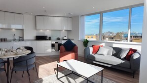 A modern apartment with a kitchen, dining area, and living room. - NEW Modern Apartment Free Parking Workspace (Gravesend)