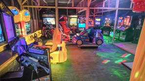 An indoor arcade with various gaming machines, including racing and shooting games.