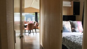 Une chambre avec un lit, une petite table et des chaises, et une vue sur l’extérieur.
