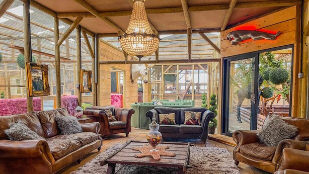 Une pièce spacieuse avec des canapés en cuir, une table basse en bois et une grande fenêtre donnant sur l’extérieur.
