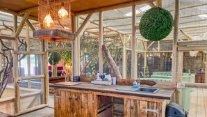 Une cuisine rustique en bois, avec un évier, des placards en bois et des luminaires suspendus.