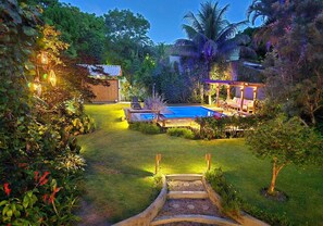 A backyard with a swimming pool, wooden deck, and outdoor seating area. - Spacious house in a large, tranquil walled garden. Close to everything. (Trancoso)