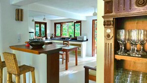 A kitchen with a central island, wooden chairs, and a dining table. - Spacious house in a large, tranquil walled garden. Close to everything. (Trancoso)