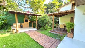 A patio with a grill, a wooden deck, and a small table. - Spacious house in a large, tranquil walled garden. Close to everything. (Trancoso)