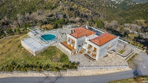 A two-story stone building with a swimming pool, surrounded by a stone wall and a metal fence. - Faris Hotel - Cozy Triple Room Near Sparta (Sparta)