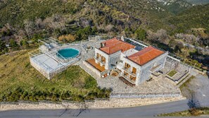 A two-story stone building with a swimming pool, surrounded by a stone wall and a fenced area. - Faris Hotel - Charming Double Room Near Sparta (Sparta)