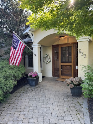 Ein Gebäudeeingang mit einer amerikanischen Flagge, einer Holztür und der Zahl 533 an der Wand.