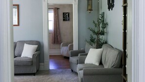 A living room with two grey sofas, a small tree, and a hanging lantern. - Country Oasis 4-bedroom farmhouse in tranquil Shelby with cozy charm (Shelby)