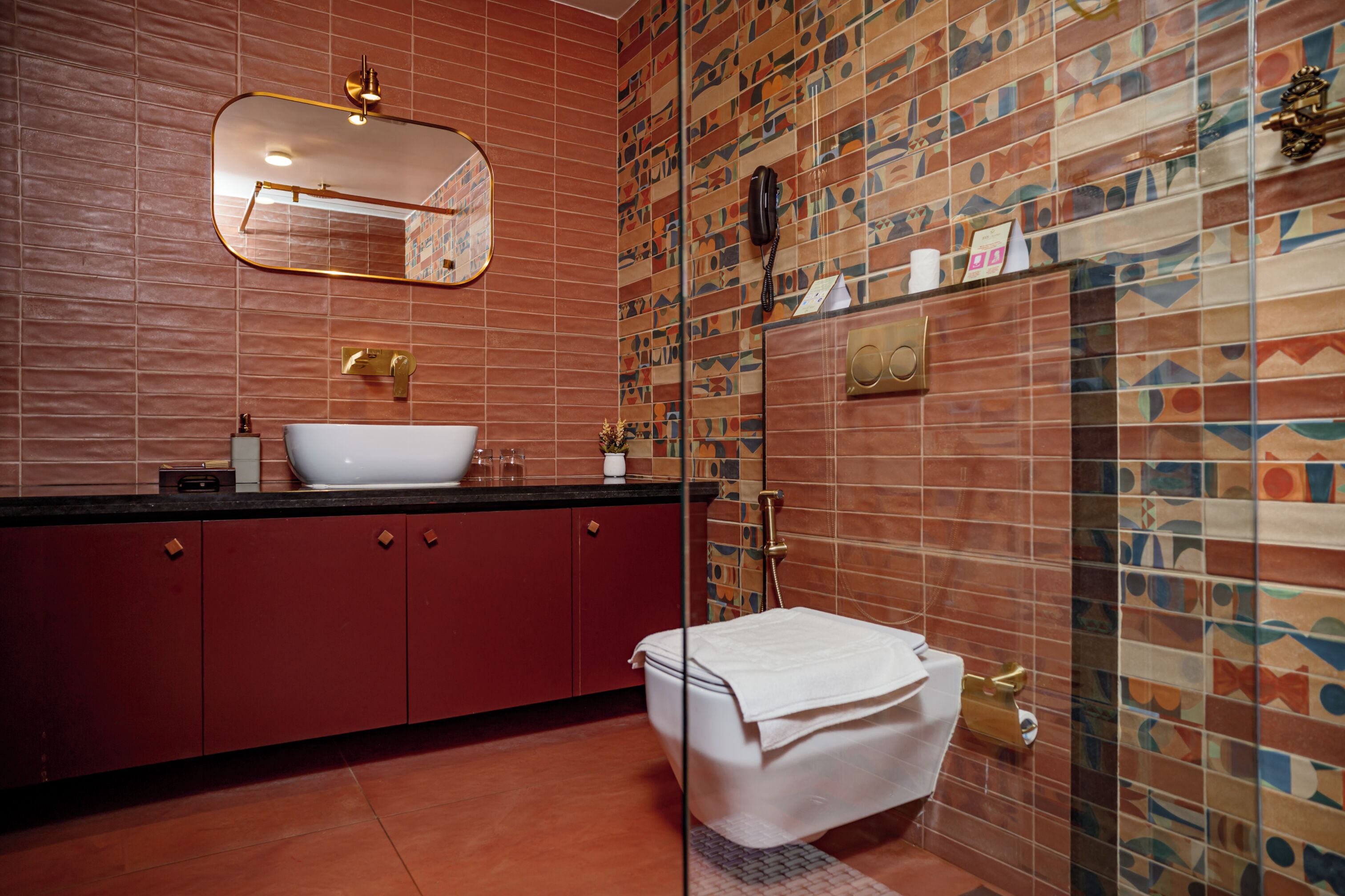 A bathroom with a sink, mirror, toilet, and shower.