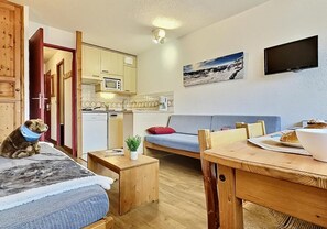 A cozy room with a bed, a sofa, a dining table, and a kitchenette. - 200m from ski slopes, 5th floor, balcony, tv, 24m², Tignes (Tignes)