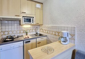 A compact kitchen with a microwave, stove, sink, and coffee maker. - 200m from ski slopes, 5th floor, balcony, tv, 24m², Tignes (Tignes)