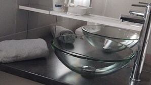 A modern bathroom with a glass bowl sink, a white towel, and a Dove soap dispenser. - A Casa bianca (Lozzi)