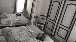 A bedroom with two beds, a chair, a nightstand, and a wardrobe. - A Casa bianca (Lozzi)