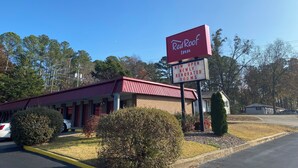 A Red Roof Inn with a red roof and a sign indicating newly renovated rooms.