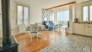 Amplia sala de estar con chimenea, una mesa de comedor y un sofá.