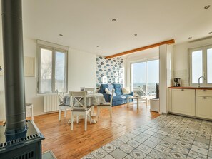 Un vaste espace de vie comprenant une cheminée, une table à manger et un canapé.