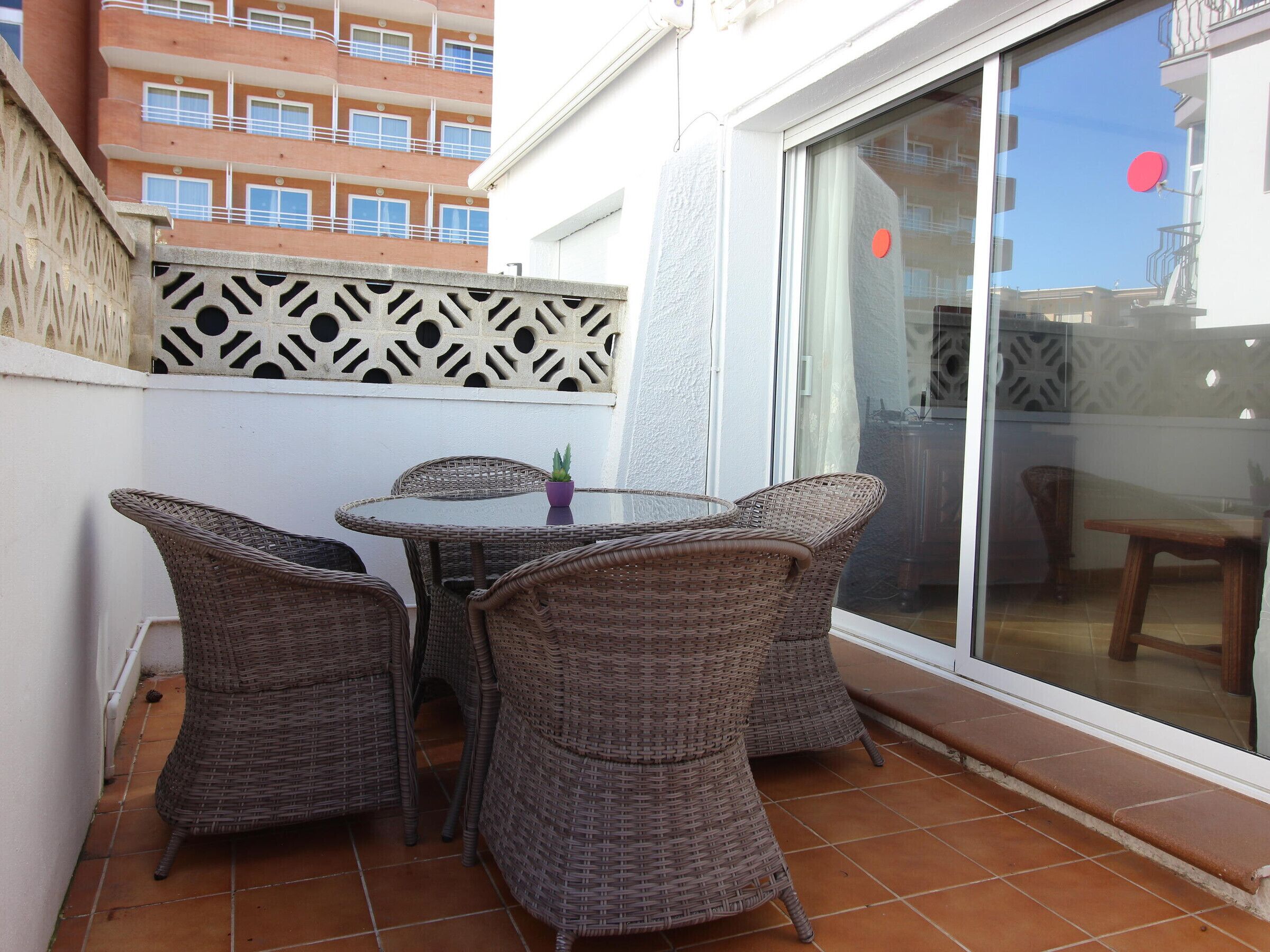 A patio with wicker furniture and a glass door.