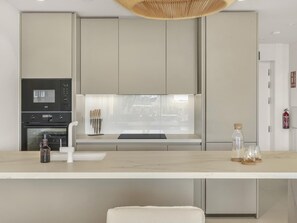 Eine moderne Küche mit Einbauofen, Mikrowelle und einem großen Fenster über der Arbeitsfläche.