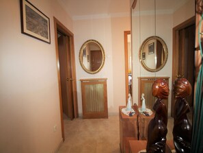 Ein Zimmer mit Holztür, Spiegel, Schminktisch und einem gerahmten Bild an der Wand.