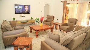 Ein Wohnzimmer mit Sofas, einem Couchtisch und einem Fernseher, der einen Musikkanal zeigt.