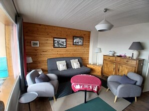 A cozy room with a bed, two armchairs, a small table, a cabinet, and a window with curtains. - Apartment 5 guests, parking, Alpe d'Huez center (Huez)