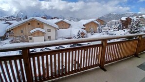 Un pueblo nevado en la montaña con edificios de madera y un cielo despejado.
