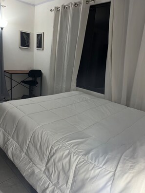 Makuuhuoneessa on sänky, työpöytä ja seinällä on kaksi kehystettyä perhoskuvaa.