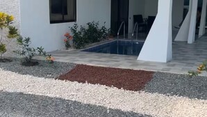 Ein modernes Gebäude mit Schwimmbad, Außenbereich und Topfpflanzen.