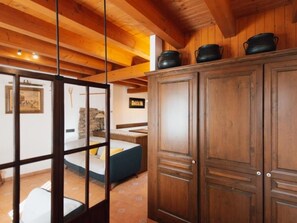 Een houten interieur met een bed, een kast en een stenen muur.