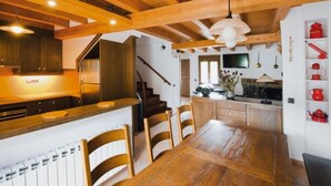Un interior de madera con cocina, comedor y una escalera.