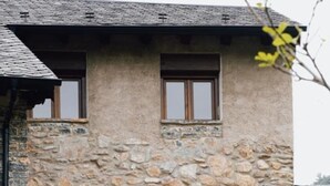 Un edificio de piedra con varias ventanas y un balcón con barandillas.