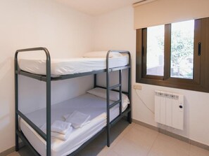 Et soveværelse med køjeseng, vindue og radiator.