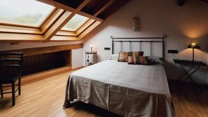A bedroom with a skylight, a bed, a chair, and a desk with a lamp. - Cozy House near Aigüestortes Park, 6 ppl, Pets welcome (Espot)