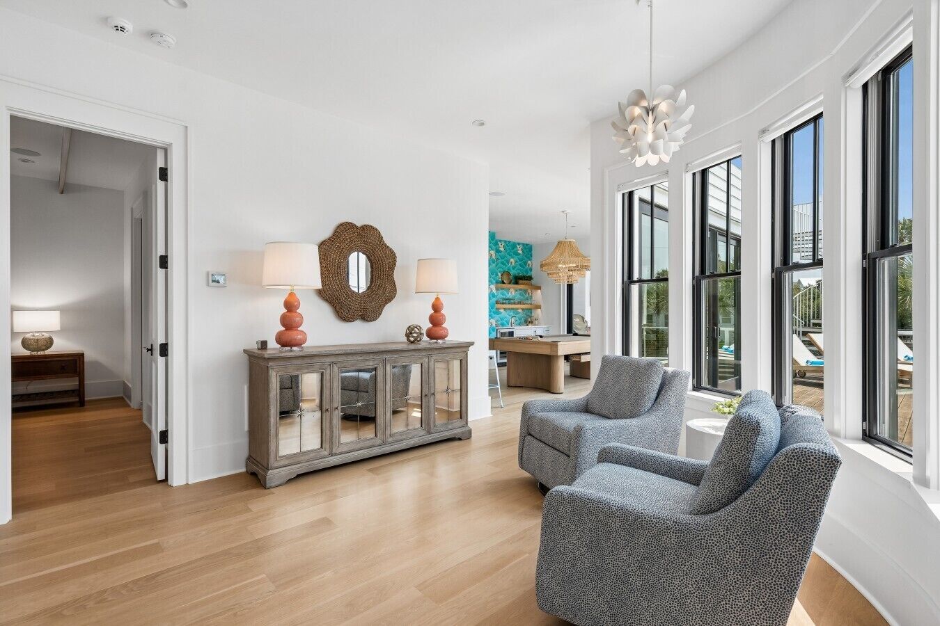 A spacious living area with a modern fireplace, a dining table, and a large window offering a view of the outdoors.