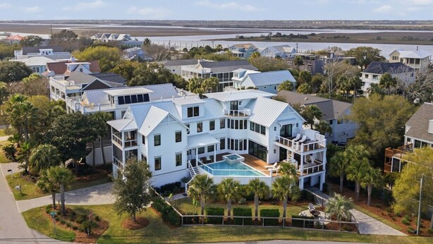 A large white house with multiple levels, a swimming pool, and a view of a body of water. - The Ivory Tide by Charleston Vacays (Isle of Palms)