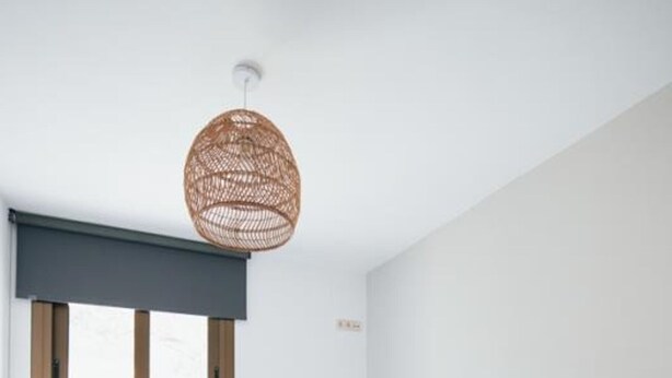 Habitación de hotel con dos camas, un ventanal grande, una lámpara de fibra natural y un cabecero de madera.